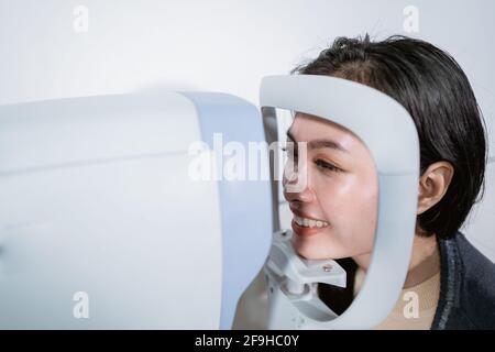 Una donna è sottoposta ad un esame con un esaminatore oculare computer Foto Stock