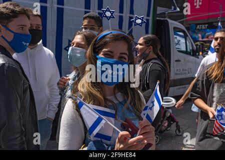 Un partecipante pone con bandiere israeliane durante le celebrazioni che segnano il 73° Yom Ha'Atzmaut (giorno dell'Indipendenza) di Israele In mezzo alla pandemia del coronavirus in Times Square a New York City.Yom Ha'Atzmaut ha cominciato al tramonto il 14 aprile e si è concluso il 15 aprile ma l'evento è stato tenuto in una domenica e organizzato dal Consiglio americano di Israele (IAC). A causa della pandemia di coronavirus in corso, la parata annuale "Celebrate Israel" che si tiene di solito a giugno lungo la Quinta strada è stata ufficialmente tenuta virtualmente. Foto Stock