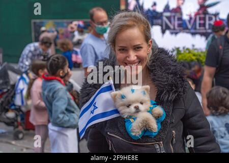 Un partecipante pone con una bandiera israeliana durante le celebrazioni che segnano il 73° Yom Ha'Atzmaut (giorno dell'Indipendenza) di Israele In mezzo alla pandemia del coronavirus in Times Square a New York City.Yom Ha'Atzmaut ha cominciato al tramonto il 14 aprile e si è concluso il 15 aprile ma l'evento è stato tenuto in una domenica e organizzato dal Consiglio americano di Israele (IAC). A causa della pandemia di coronavirus in corso, la parata annuale "Celebrate Israel" che si tiene di solito a giugno lungo la Quinta strada è stata ufficialmente tenuta virtualmente. Foto Stock