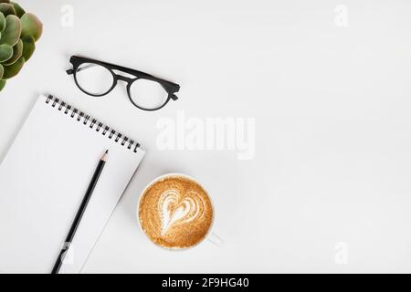 scrivania da ufficio, spazio di lavoro con notebook, matita, occhiali. caffè e piante verdi. Background aziendale. Disposizione piatta, vista dall'alto, spazio per la copia. Foto Stock