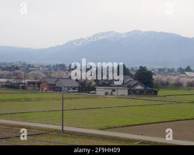 KANAZAWA, GIAPPONE - 8 aprile 2014: Stile di vita contadino: Campi di riso con la montagna. Catturato da un autobus nella campagna di Kanazawa. Foto Stock