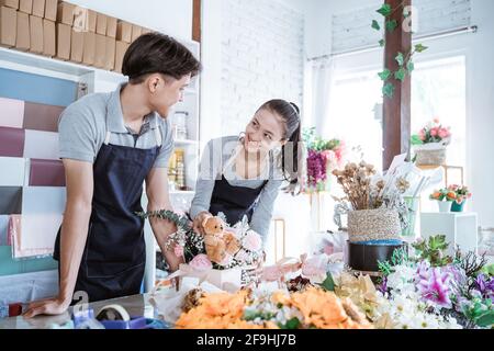 felice giovane uomo e femmina sorridente parlando mentre lavorano insieme Foto Stock