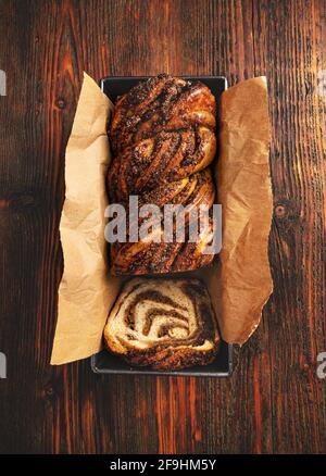 Piatto di noce babka casereccia, brioche swirl con noce su fondo di legno Foto Stock