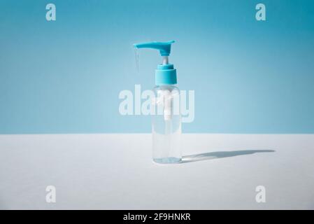 Dispenser con gel trasparente su fondo azzurro. Foto Stock