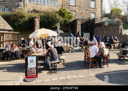 Le persone si riuniscono per godersi una giornata fuori con bevande al pub con birreria all'aperto nel centro della città di Holmfirth, nel West Yorkshire, Inghilterra. Foto Stock