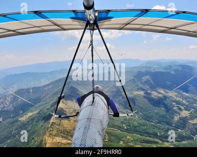 I piloti di deltaplano corrono in alta quota sopra i crinali di montagna. Sport estremi Foto Stock