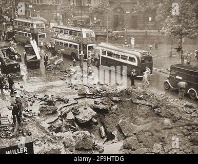 Seconda guerra mondiale - bombardamenti tedeschi su Londra, Regno Unito (Blitz) nel settembre 1940 - gli autobus vintage di Londra passano davanti a un cratere di bomba nello Strand. Foto Stock