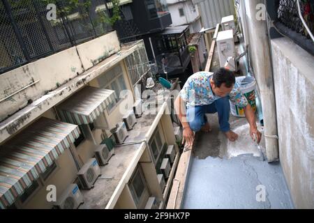 Lavoro con la spazzola a rullo, per impermeabilizzazione sul tetto. Ristrutturazione della casa a Bangkok, Thailandia. 5 ottobre 2019 Foto Stock