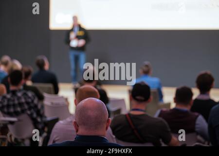 Il pubblico ascolta l'oratore maschile al workshop nella sala conferenze Foto Stock