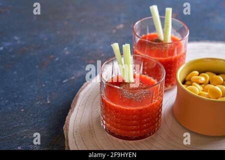 Succo di pomodoro in due bicchieri con aperitivo lupino. Bloody Mary, cocktail Foto Stock