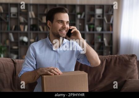 Sorridente cliente maschio acquistare online parlando sul cellulare Foto Stock