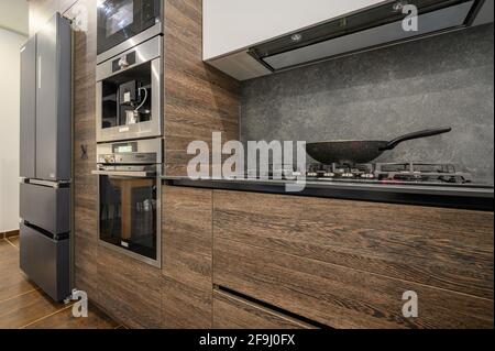 Moderno e lussuoso, con grandi dettagli della cucina marrone scuro, grigio e nero Foto Stock