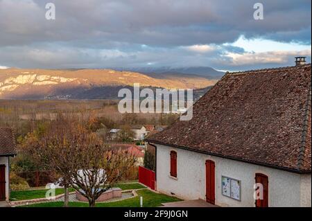 Vista prospettica dal tetto in tegole di una piccola casa, caratterizzata da colline sullo sfondo che coprono le nuvole tempestose a le Pont de Beauvoisin Foto Stock