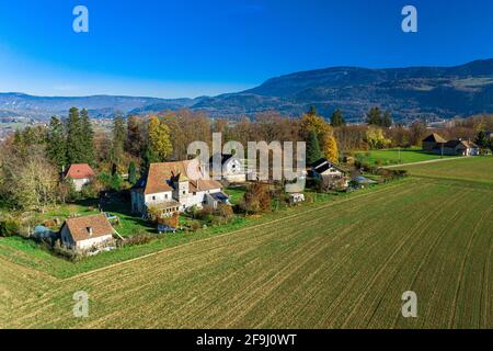 Vista aerea del drone di una piccola città situata di fronte alle possenti alpi. Foto Stock