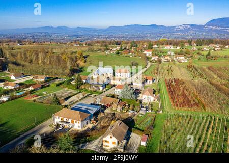 Vista aerea del drone di una piccola città situata di fronte alle possenti alpi. Foto Stock