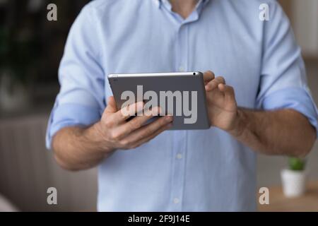Primo piano dell'uomo che usa il tablet che lavora online Foto Stock