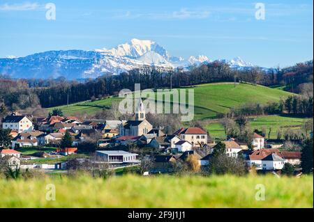 Scatto cinematografico di piccola città situata nel giro della natura in Francia, Europa con le alpi innevate catena montuosa in piedi alto sullo sfondo. Foto Stock