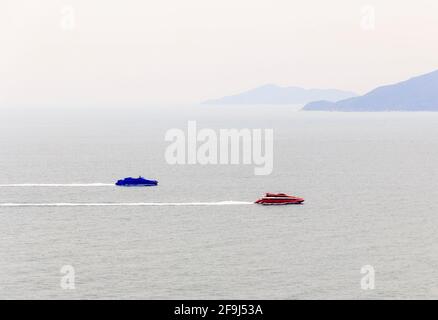 Un jet boat rosso e blu si muovono velocemente sul mare. Foto Stock