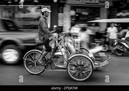 Un pilota pedicab cercando clienti, Phnom Penh Cambogia. Foto Stock