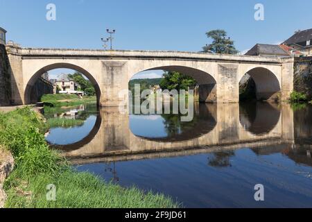 Un vecchio ponte di pietra sul fiume Vézère, e la sua riflessione, a Montignac, Dordogna, Francia Foto Stock