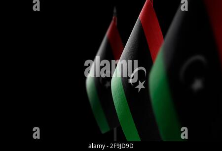 Piccole bandiere nazionali della Libia su sfondo nero Foto Stock