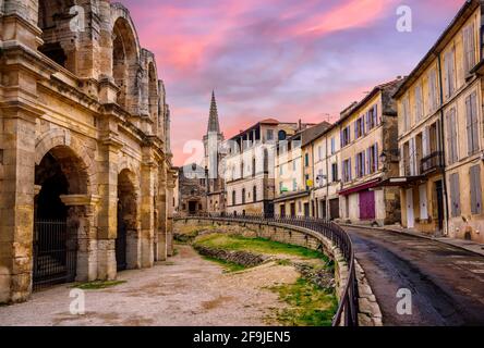 Arles Città Vecchia e anfiteatro romano, Provenza, Francia nel drammatico la luce del tramonto Foto Stock