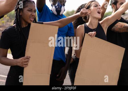 Manifestazione pubblica sulla strada contro il riscaldamento globale e l'inquinamento, no vax, razzismo. Gruppo di persone multietniche che protestano per il chan climatico Foto Stock