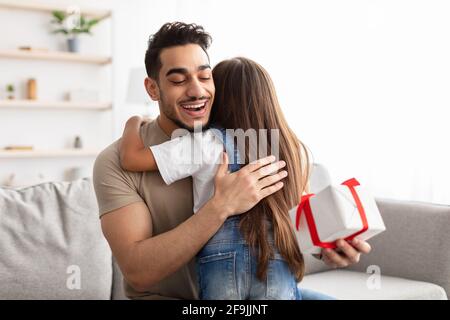 Amorevole ragazza che celebra il giorno del padre, saluto eccitato papà con box Foto Stock