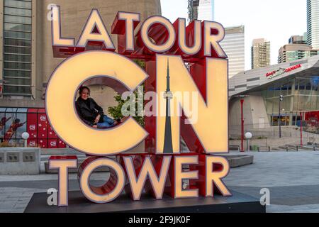 I turisti che hanno la loro foto scattata all'insegna della CN Tower, Toronto, Canada Foto Stock