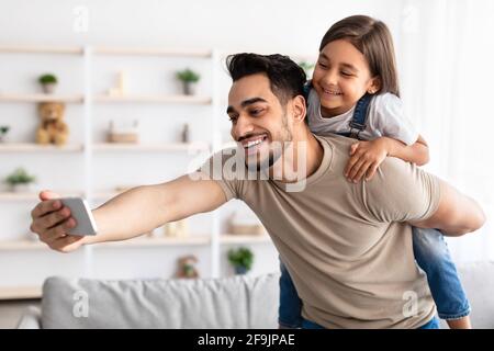 Il padre allegro che prende selfie con la figlia carina Foto Stock