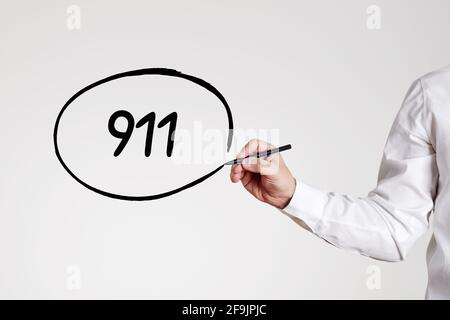 Uomo d'affari scrive il numero 911 con un cerchio di contorno. Concetto delle chiamate di emergenza. Foto Stock