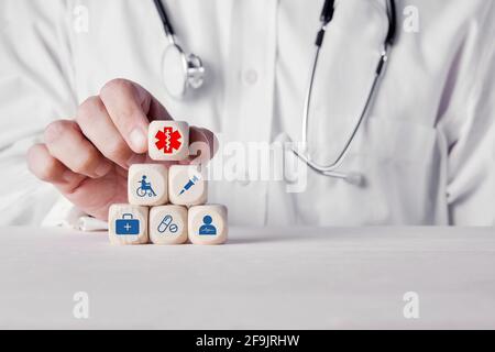 Mano di un medico che mette i cubi di legno con le icone mediche di salute. Concetto di salute e medicina. Foto Stock