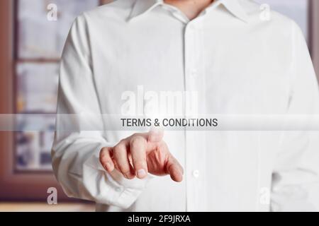 La mano maschile preme il pulsante termini e condizioni su un touch screen virtuale. Concetto di termini e condizioni aziendali. Foto Stock