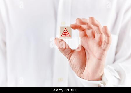 Mason Hand tiene un cubo di legno con l'occhio della provvidenza o tutti gli occhi vedendo simbolo di dio. Concetto massonico in muratura. Foto Stock
