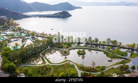 (210419) -- NINGLANG, 19 aprile 2021 (Xinhua) -- Foto aerea scattata il 17 aprile 2021 mostra un progetto di costruzione di una cintura ecologica sul lago e di restauro di zone umide del lago di Lugu nel villaggio di Lige, città di Yongning, contea autonoma di Ninglang Yi, nella provincia di Yunnan nella Cina sud-occidentale. Confinante con la provincia del Sichuan, il Lugu è il lago più alto dello Yunnan, che si erge a circa 2,700 metri sul livello del mare e circondato da montagne ricoperti di foresta. Conosciuto come la "perla scintillante incastonata nell'altopiano", il lago Lugu svolge un ruolo chiave nell'equilibrio dell'ambiente locale. Il lago di Lugu ha visto una migliore qualità dell'acqua in recen Foto Stock