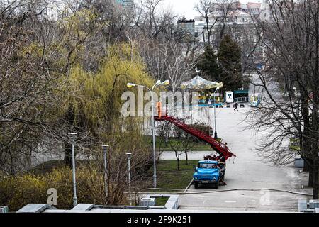 Dnepropetrovsk, Ucraina - 04.12.2021: Un operaio comunale in dispositivi di protezione che sostituisce le lampadine in una lampada da strada. Un lavoratore che ripara una lampada di strada di un bu Foto Stock