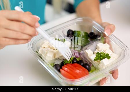 mani di donna che mangiano togliere il cibo dal contenitore Foto Stock