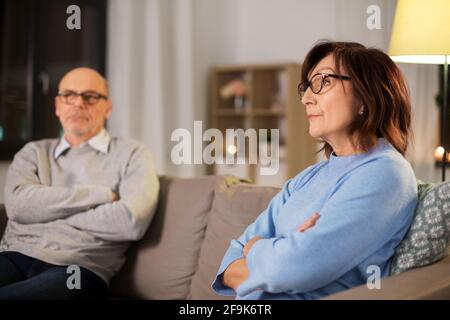 una coppia anziana infelice che si siede sul divano di casa Foto Stock