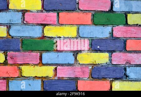 Arcobaleno colorato muro di mattoni sfondo. Pietre colorate del muro Foto Stock