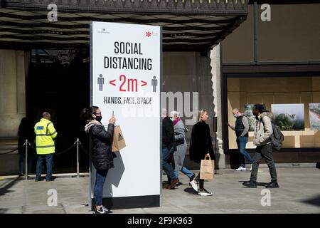 Londra, Inghilterra, Regno Unito. Oxford Street, Selfridges, riaperto dopo il blocco 3. Segno che ricorda la gente alla distanza sociale ed una donna che prende un selfie. Foto Stock