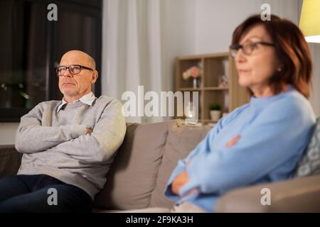 una coppia anziana infelice che si siede sul divano di casa Foto Stock