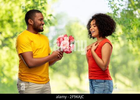 felice coppia afroamericana con fiori Foto Stock