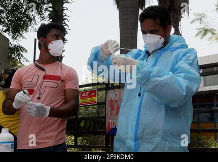 Gli operatori sanitari che indossano dispositivi di protezione individuale (DPI) si preparano a raccogliere campioni di tamponi nasali per un test rapido sull'antigene Covid-19 lungo la strada a Nuova Delhi. Il ministro capo Arvind Kejriwal di Delhi annuncia di imporre un blocco dalle 22:00 per 7 giorni per affrontare i crescenti casi di Covid-19 nella capitale. (Foto di Naveen Sharma / SOPA Images/Sipa USA) Foto Stock