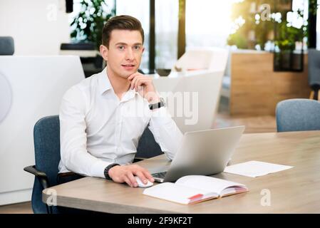 Uomo d'affari che lavora in ufficio. Interni moderni per uffici sullo sfondo Foto Stock