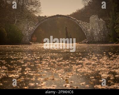 Notte invernale con Rakotzbrücke sul lago, Azalea e Rhododendron Park Kromlau. Un posto fantastico in Germania. Rakotzbrucke conosciuto anche come Devils Bridge. Foto Stock