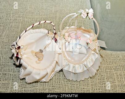 Due bellissimi cestini decorati con tessuti con anelli da sposa e un arra interno. Set preparato per celebrare un matrimonio. Foto Stock
