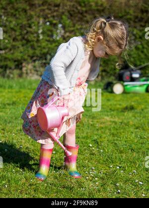 Toddler che annaffia i suoi wellingtons, Regno Unito Foto Stock