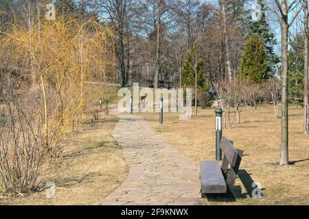 Frammento del parco di Mezhyhirya vicino a Kiev. Un bel sentiero con panchine per il relax. Foto Stock