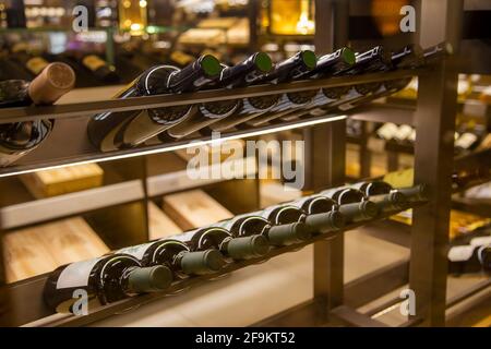 Cantina con bevande d'élite sugli scaffali. Bottiglie di vino nel negozio. Primo piano. Foto Stock