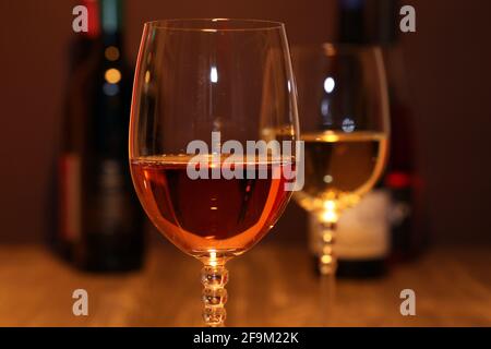 Primo piano di due bicchieri di vino con bottiglie di vino in lo sfondo Foto Stock